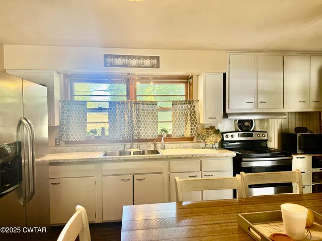 a kitchen with stainless steel appliances a sink a stove and a refrigerator