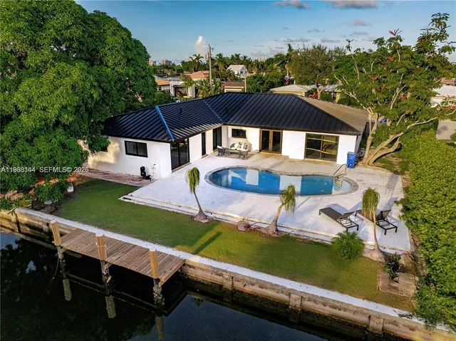 an aerial view of a house with swimming pool garden and patio