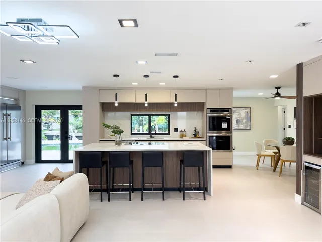 a large kitchen with kitchen island a sink a stove a dining table and chairs