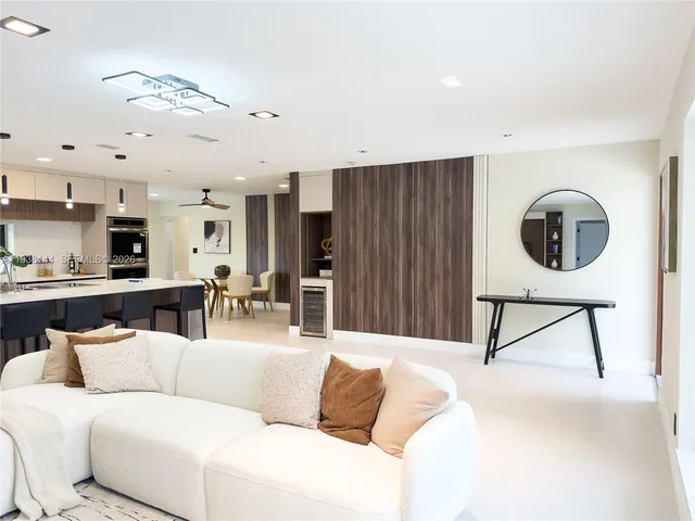 a living room with furniture and a view of kitchen