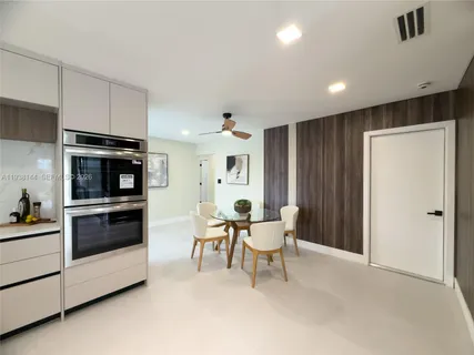 a living room with furniture and stainless steel appliances