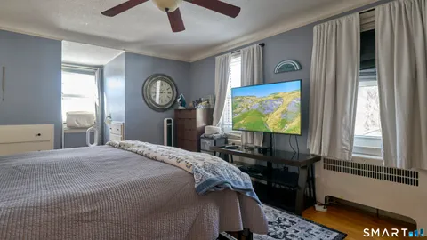 a bedroom with a bed and painting on the wall