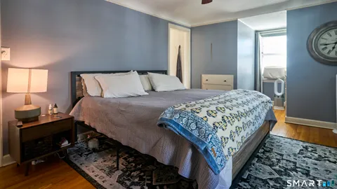 a bedroom with bed and wooden floor