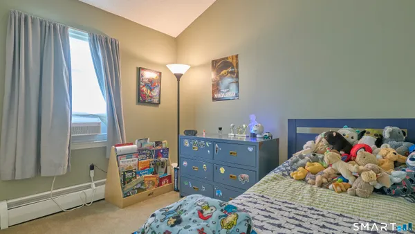 a bedroom with a bed and painting on the wall