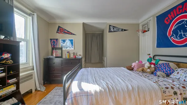 a bedroom with bed and wooden floor