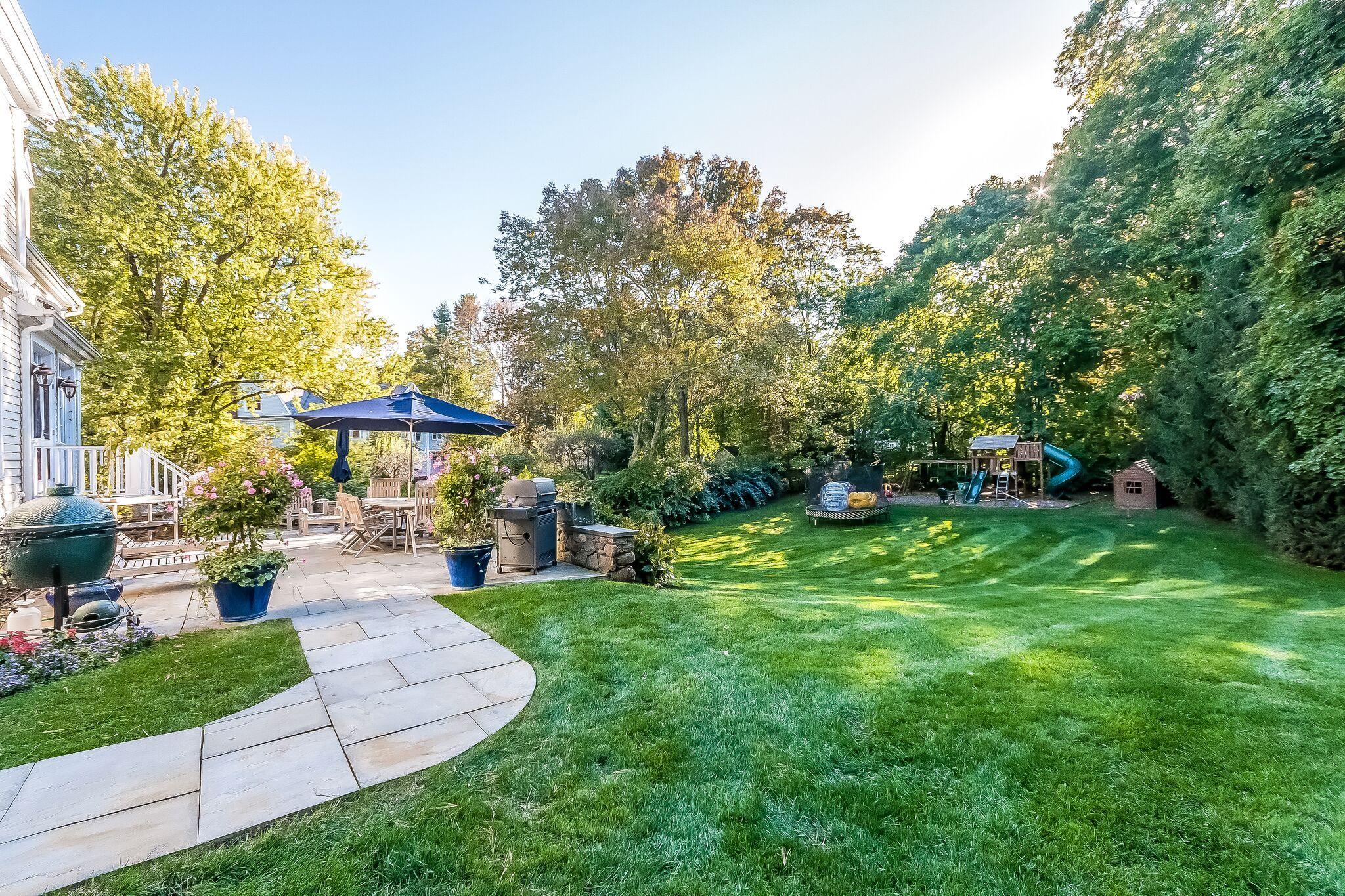 364 Smith Ridge Road New Canaan, CT 06840 - Photo 36 of 39 a view of a backyard with table and chairs under an umbrella