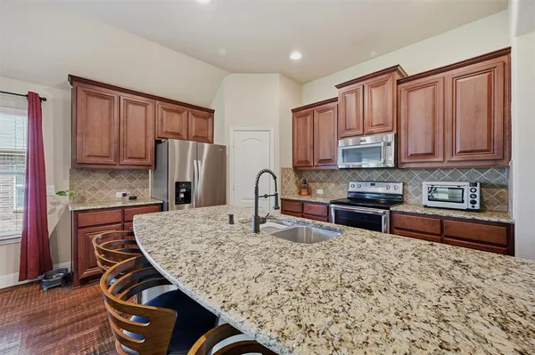 a kitchen with stainless steel appliances granite countertop a refrigerator stove and sink