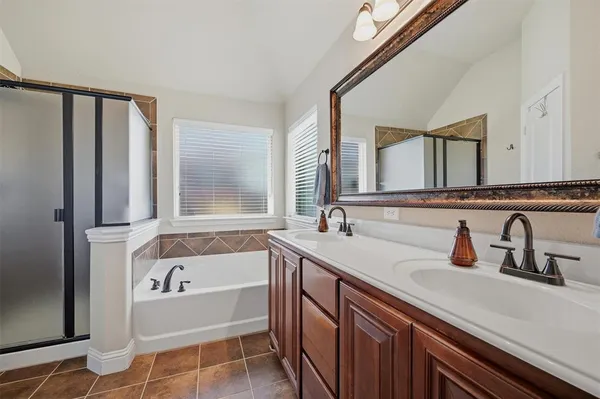 a bathroom with a granite countertop sink and a bathtub