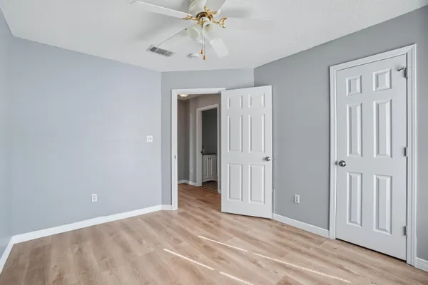 a view of a room with a chandelier fan and closet area