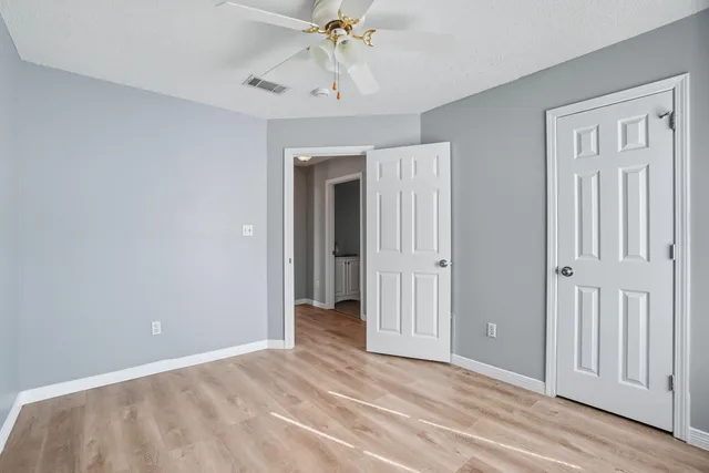 a view of a room with a chandelier fan and closet area