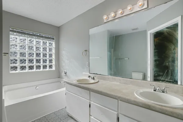 a bathroom with a bathtub a sink and a large mirror