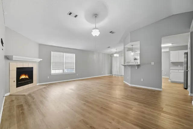 a view of empty room with wooden floor and fireplace