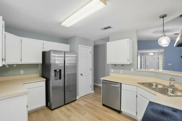 a kitchen with a sink cabinets stainless steel appliances and a window