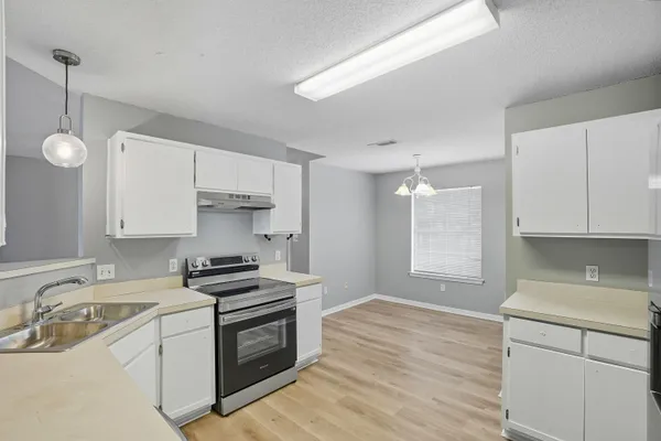 a kitchen with a sink stove top oven and cabinets