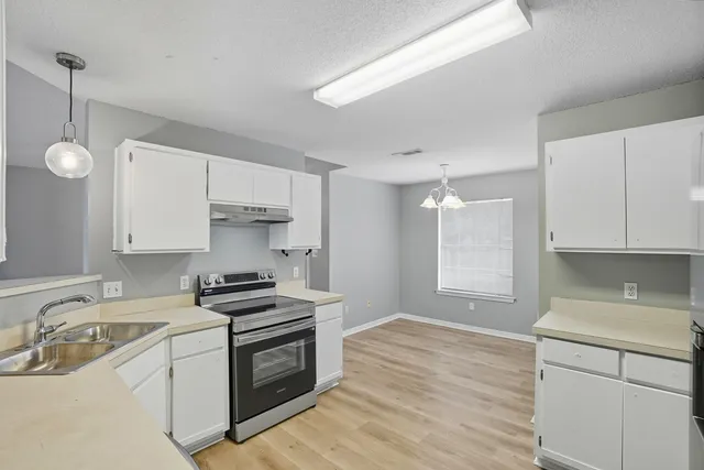 a kitchen with a sink stove top oven and cabinets