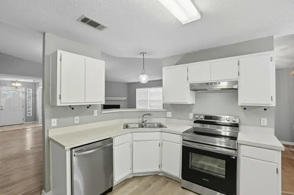 a kitchen with cabinets stainless steel appliances and sink