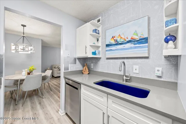 a kitchen with a sink cabinets and wooden floor
