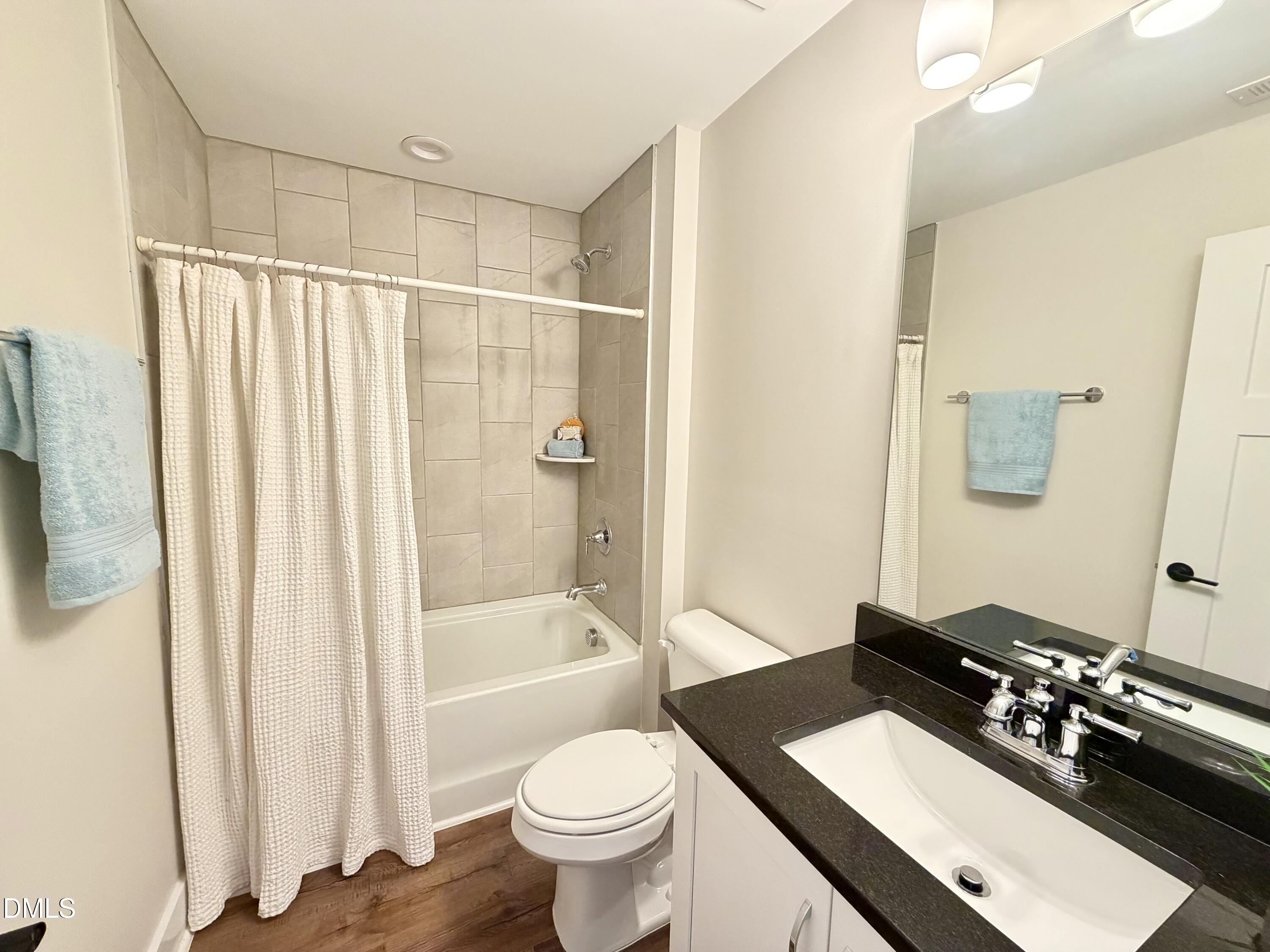 4016 Emerald Green Road Raleigh, NC 27612 - Photo 15 of 22 a bathroom with a sink toilet a mirror and shower