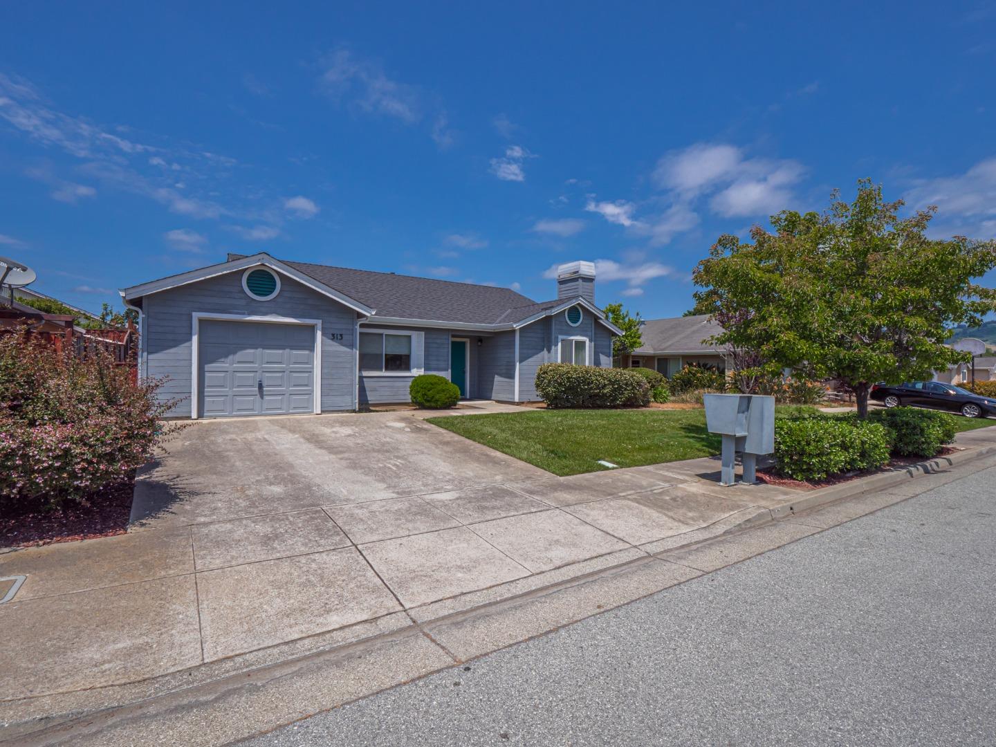 a front view of a house with a garden and trees