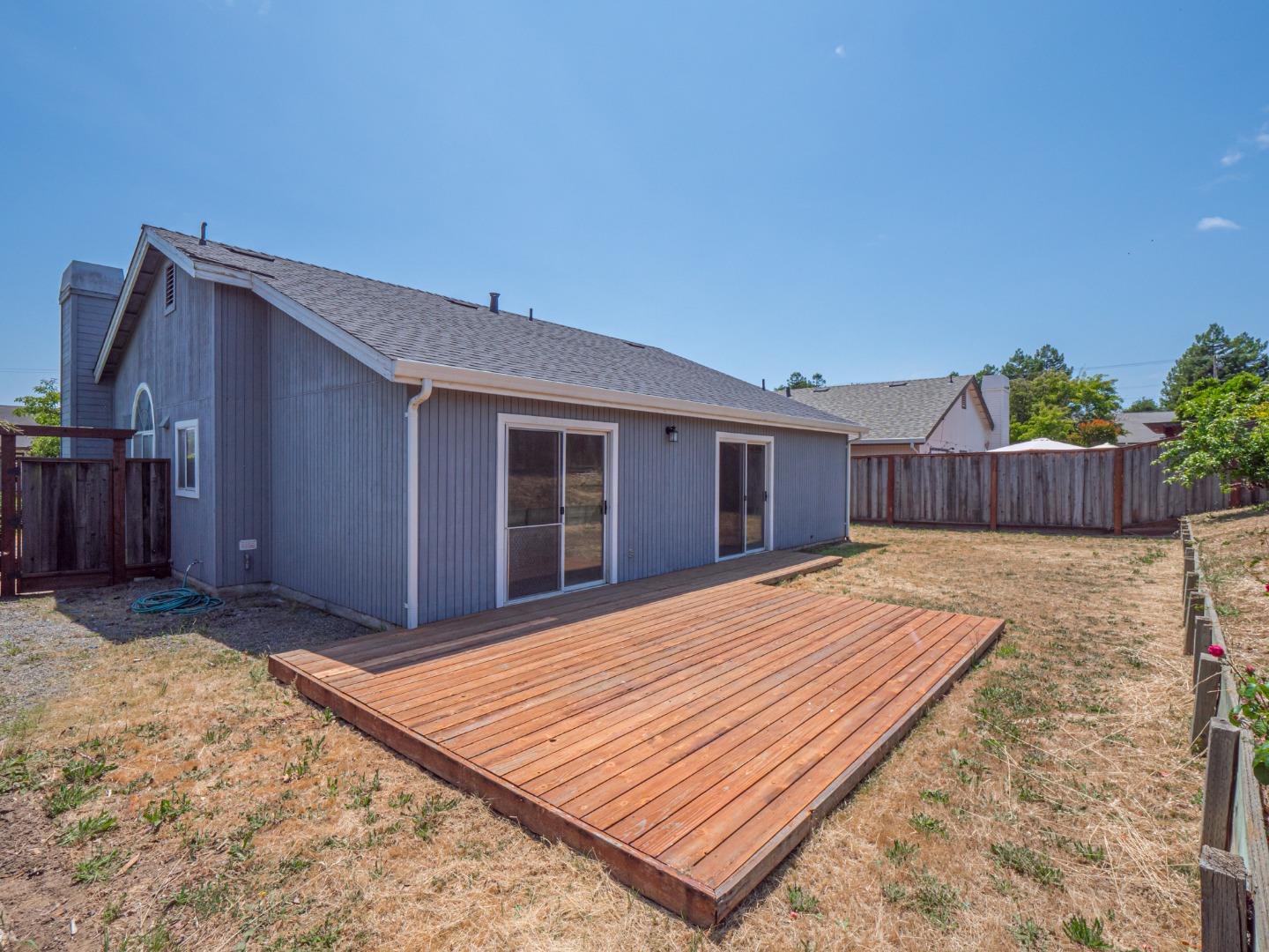 313 Sombra Watsonville, CA 95076 - Photo 7 of 37 a view of a backyard with a barbeque and wooden fence