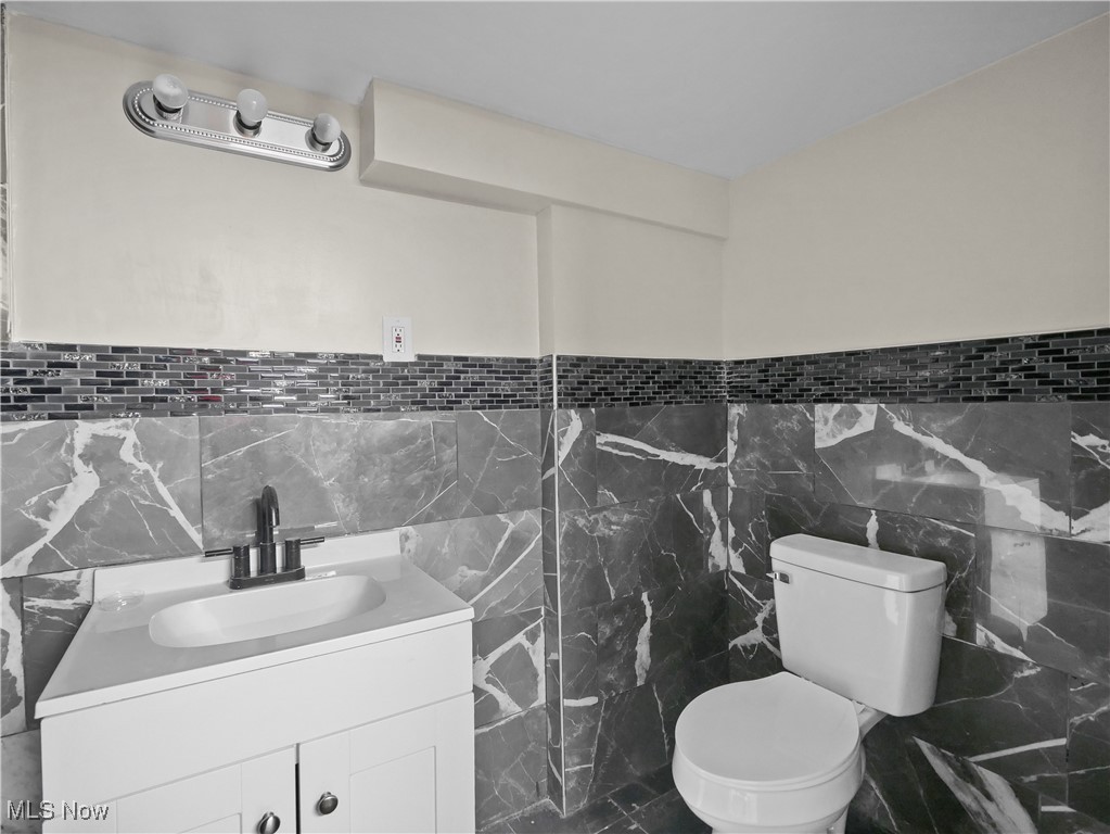 32 North Hillside Road Canfield, OH 44406 - Photo 28 of 38 Bathroom featuring toilet, vanity, and tile walls