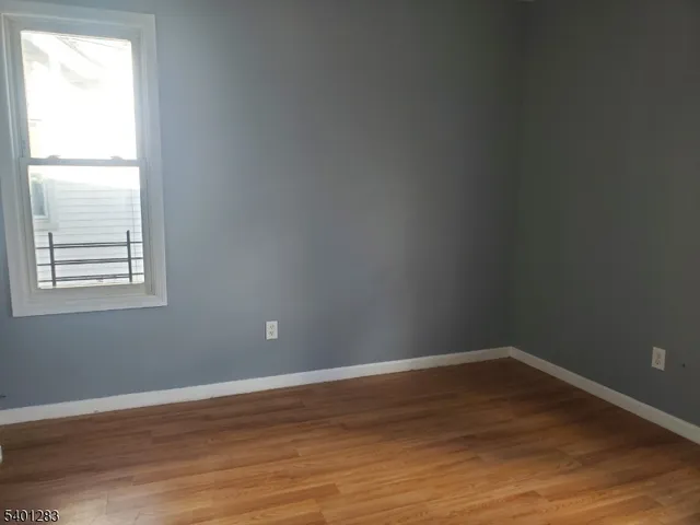 a view of a small space with wooden floor and a window