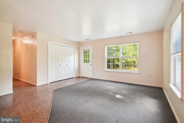 an empty room with windows and closet