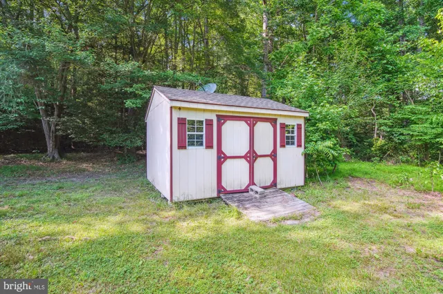 a sign that is sitting in the grass with a small garden