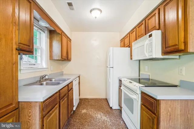 a kitchen with stainless steel appliances granite countertop a sink and a refrigerator