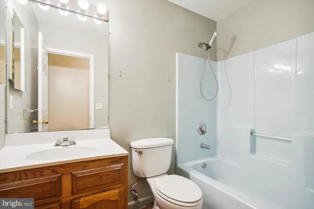 a bathroom with a sink toilet vanity and shower