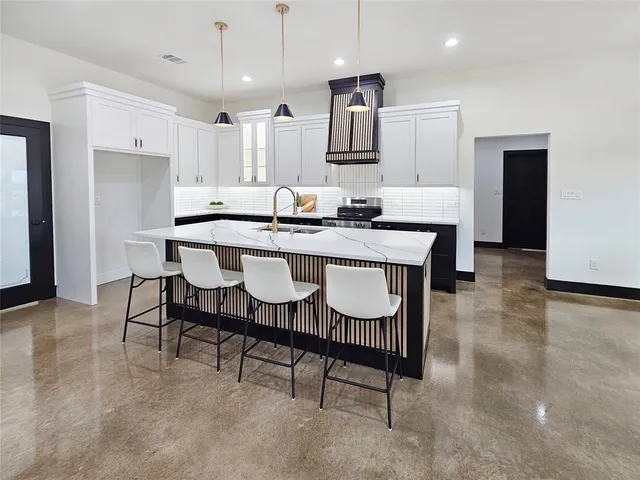 a large kitchen with a table and chairs