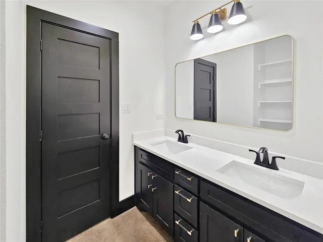 a bathroom with a double vanity sink and mirror