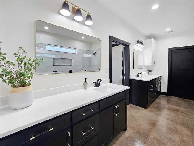 a spacious bathroom with a double vanity sink a mirror and a shower