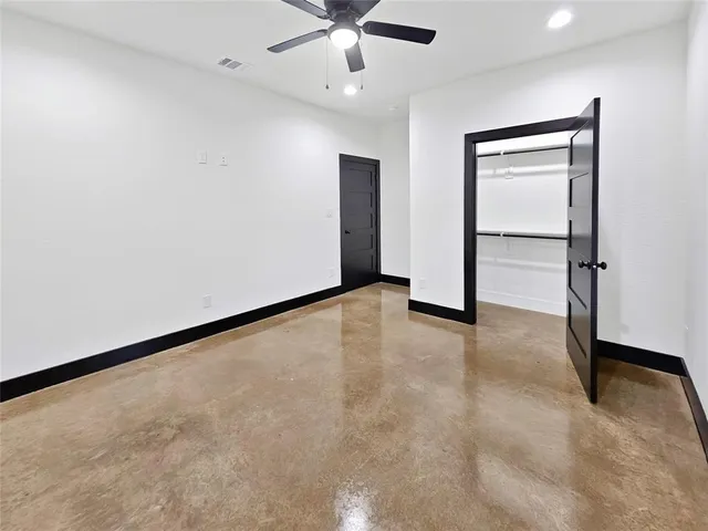 an empty room with closet and a ceiling fan