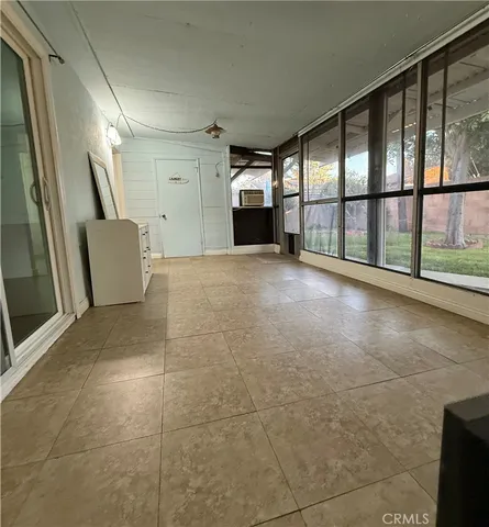 a view of an empty room with a fireplace and a large window