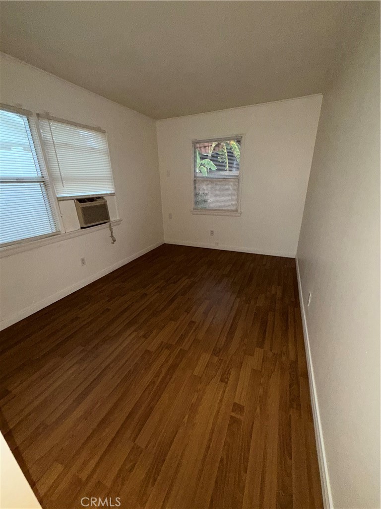 7012 Forbes Avenue Van Nuys, CA 91406 - Photo 6 of 9 a view of an empty room with wooden floor and a window