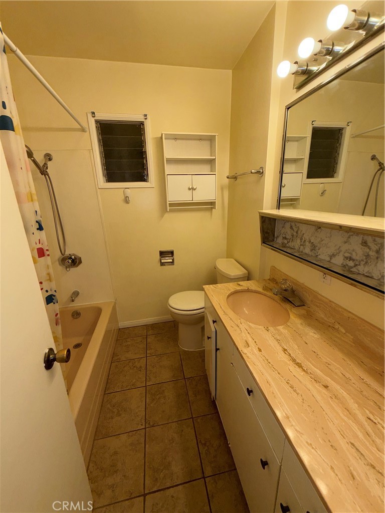 7012 Forbes Avenue Van Nuys, CA 91406 - Photo 7 of 9 a spacious bathroom with a granite countertop sink a toilet and mirror