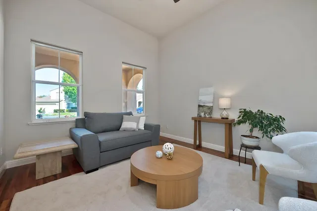 a dining room with furniture potted plants and wooden floor