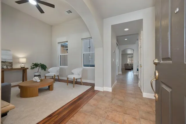 a living room with furniture a window and a potted plant