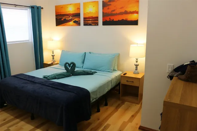 a bedroom with a bed and wooden floor