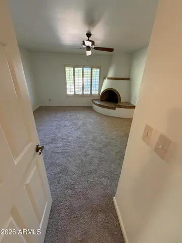 a view of empty room with wooden floor and fireplace