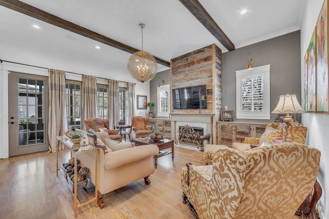 a living room with furniture kitchen view and a large window