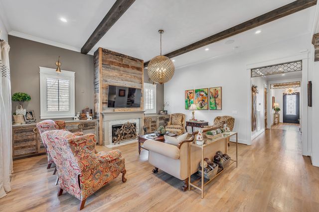 a large white kitchen with a large window a counter space a sink stainless steel appliances and cabinets