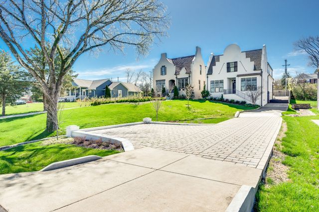 a front view of a house with a yard and trees
