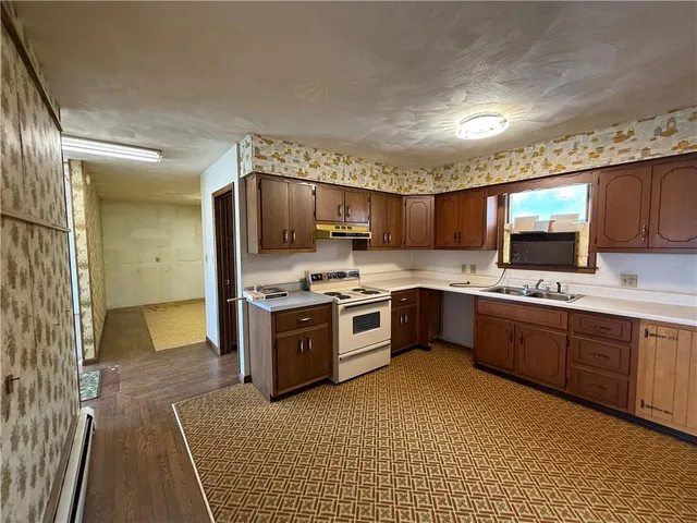 a kitchen with a sink a stove and cabinets