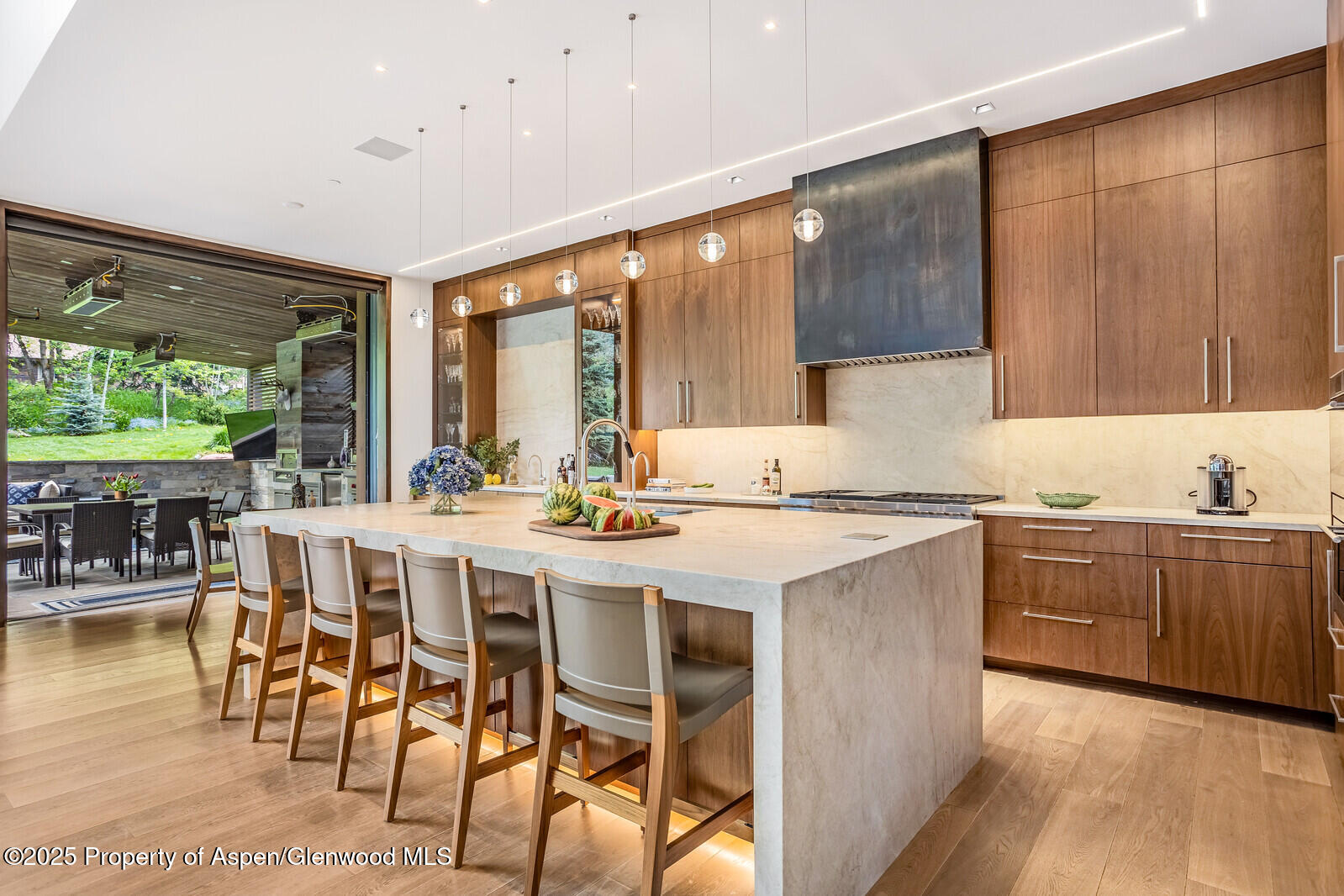 130 Primrose Path Aspen, CO 81611 - Photo 9 of 94 a kitchen with stainless steel appliances granite countertop a table chairs sink and wooden cabinets