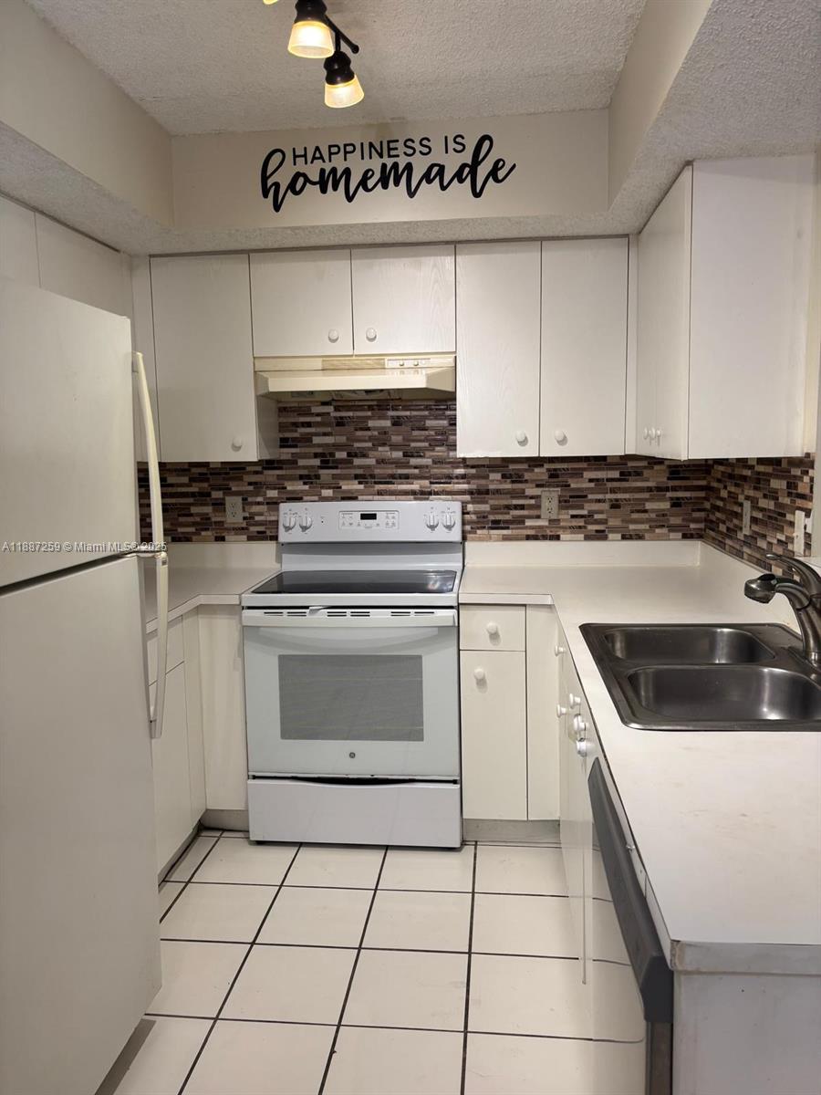 a kitchen with cabinets and white appliances