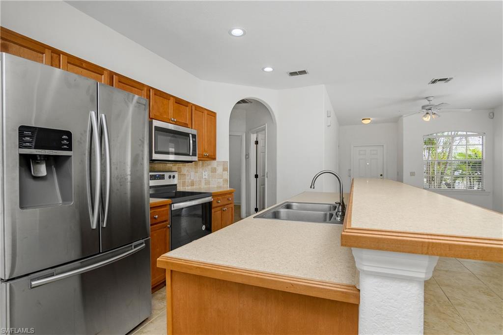 2119 River Ridge Boulevard Fort Myers, FL 33905 - Photo 3 of 19 Kitchen with tasteful backsplash, appliances with stainless steel finishes( new stove Microwave and Dishwasher installed at closing), sink, and a center island with sink