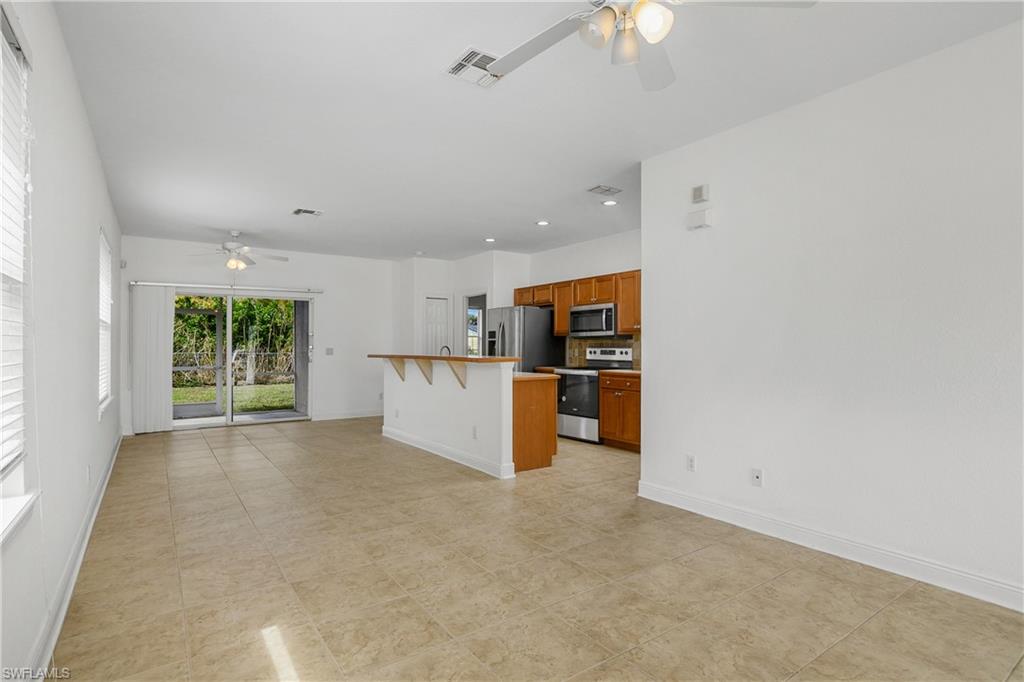 2119 River Ridge Boulevard Fort Myers, FL 33905 - Photo 5 of 19 Kitchen with a kitchen bar, a center island, ceiling fan, and appliances with stainless steel finishes