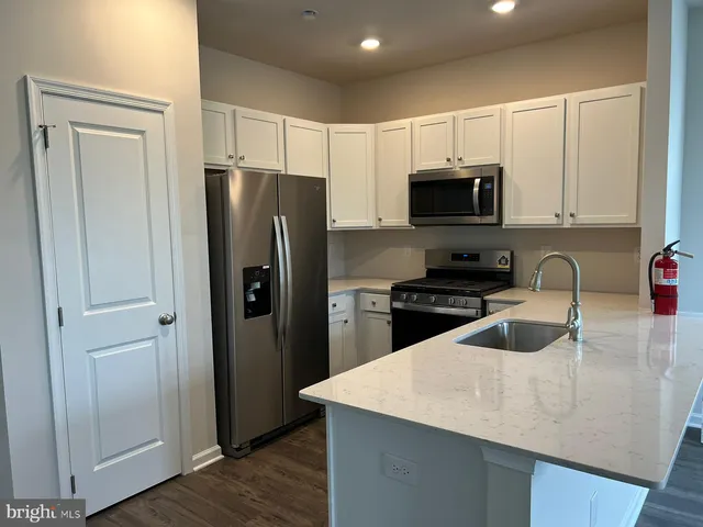 a kitchen with granite countertop a refrigerator and a sink